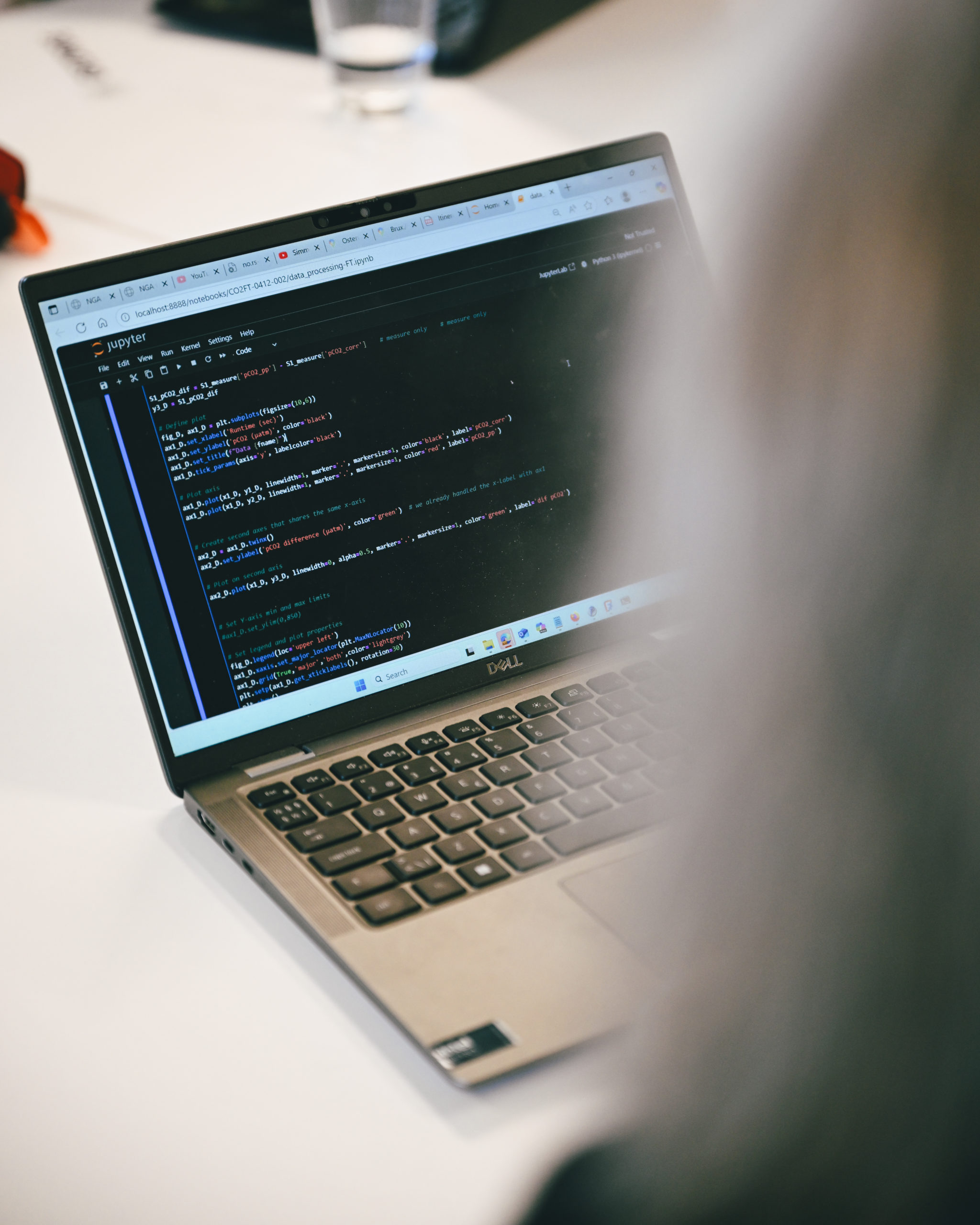 Laptop on a table with rows of code on the creen